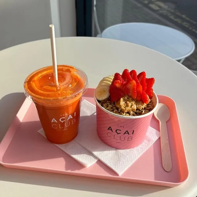 Açai bowl with peanut butter, strawberries, banana and granola paired with fresh carrot juice
